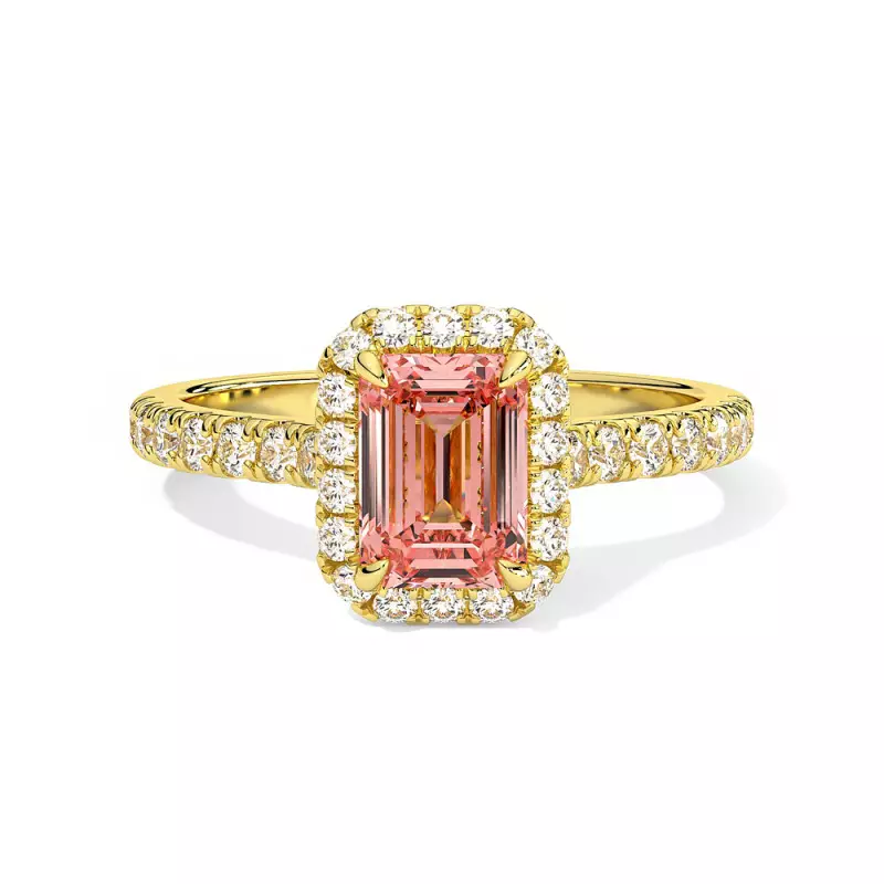 Bague en or jaune avec un diamant rose taillé en émeraude entouré d'un halo de diamants blancs.