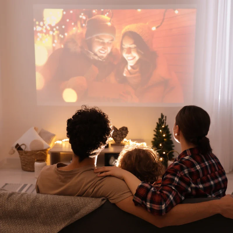 Une famille regardant une vidéo sentimentale projetée sur un mur, une idée originale et personnelle pour une demande en mariage.