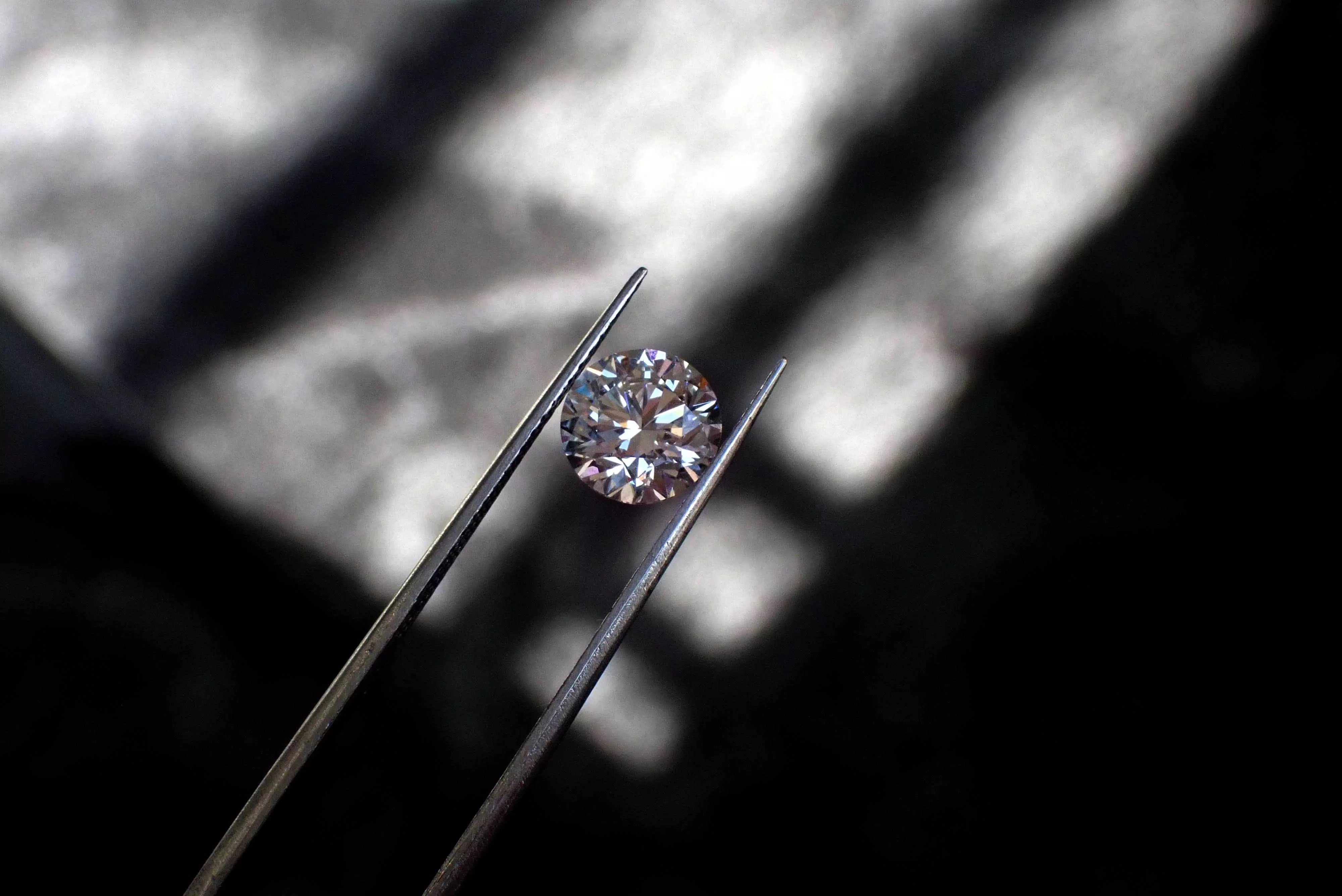 Diamant synthétique vu de près tenu par une pince